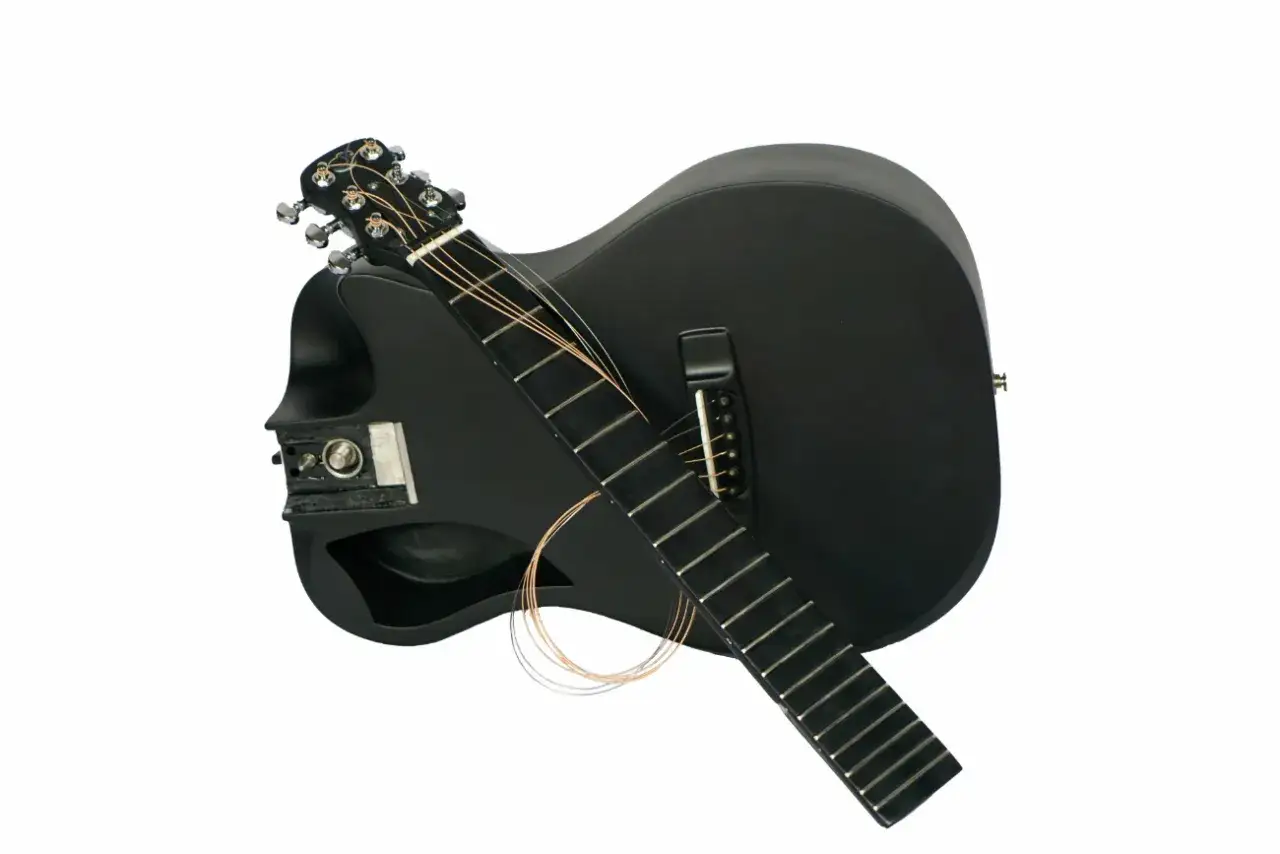 Dwie czarne gitary, jedna na drugiej. Na gryfie jednej gitary leżą luźne struny. To wyjątkowe gitary marki Ruf Guitars.
