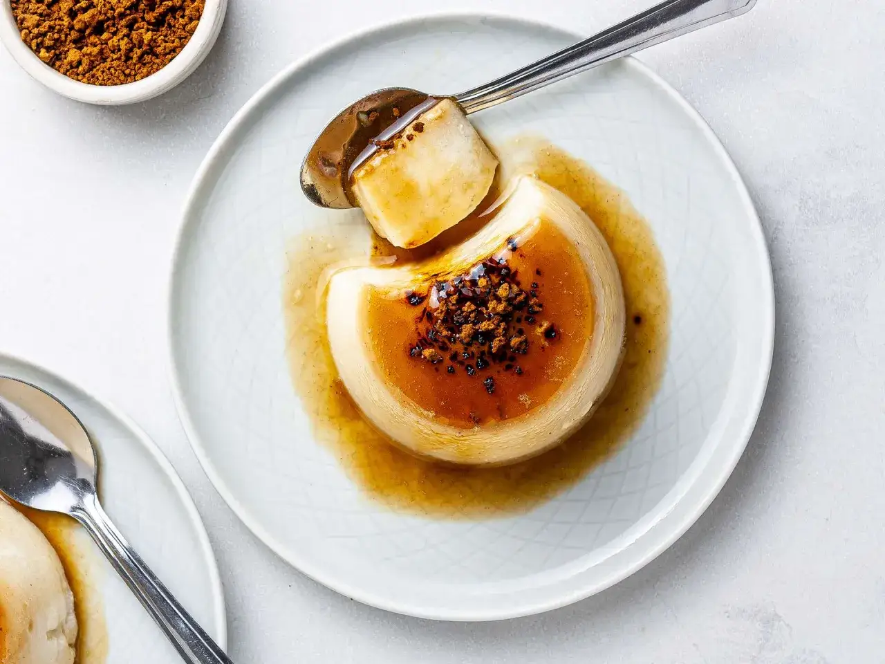 Delicioso flan de café con caramelo líquido y granos de café espolvoreados. Una cucharada lista para disfrutar.