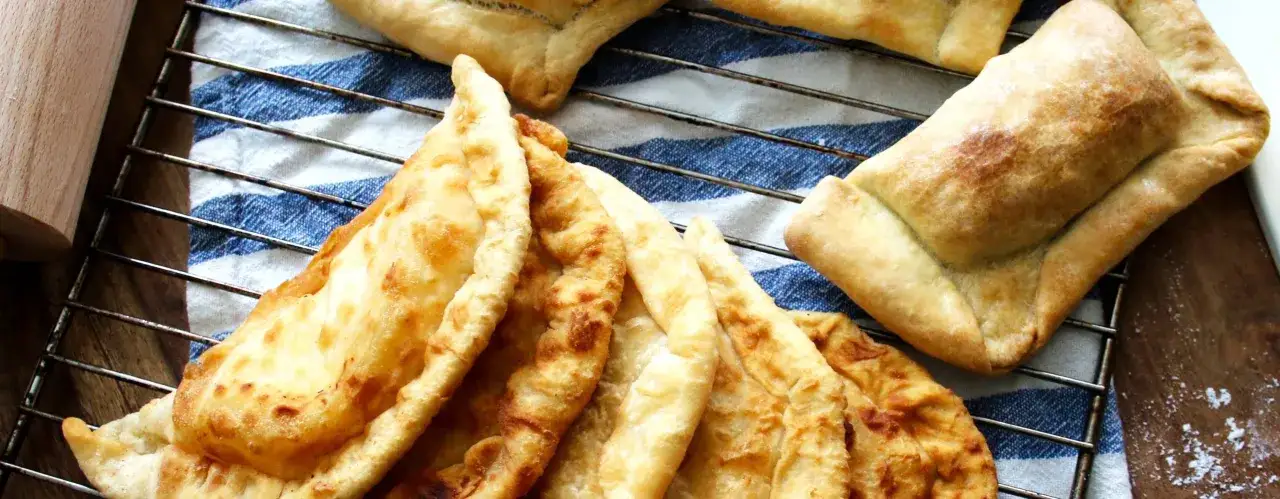 Nybakade empanadas p&aring; ett galler, redo att avnjutas. Ett perfekt empanadas recept f&ouml;r hemmabruk.