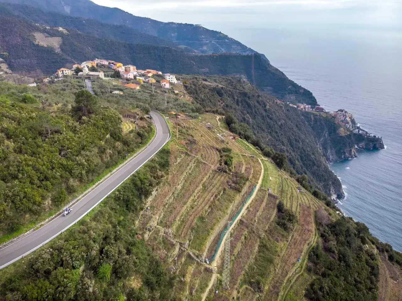 Un viaggio in moto tra i terrazzamenti e i borghi delle 5 Terre, con il mare blu a fare da sfondo.