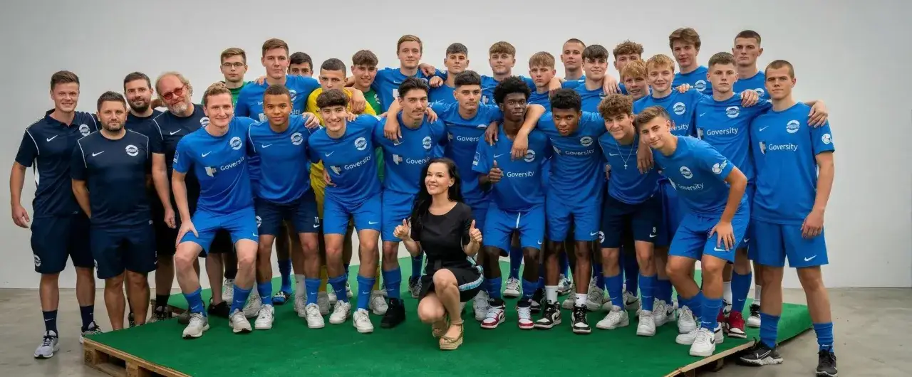 Ein Fu&szlig;ballteam posiert f&uuml;r ein Foto. Ein sport master und seine Spieler in blauen Trikots sind bereit f&uuml;r das n&auml;chste Spiel.