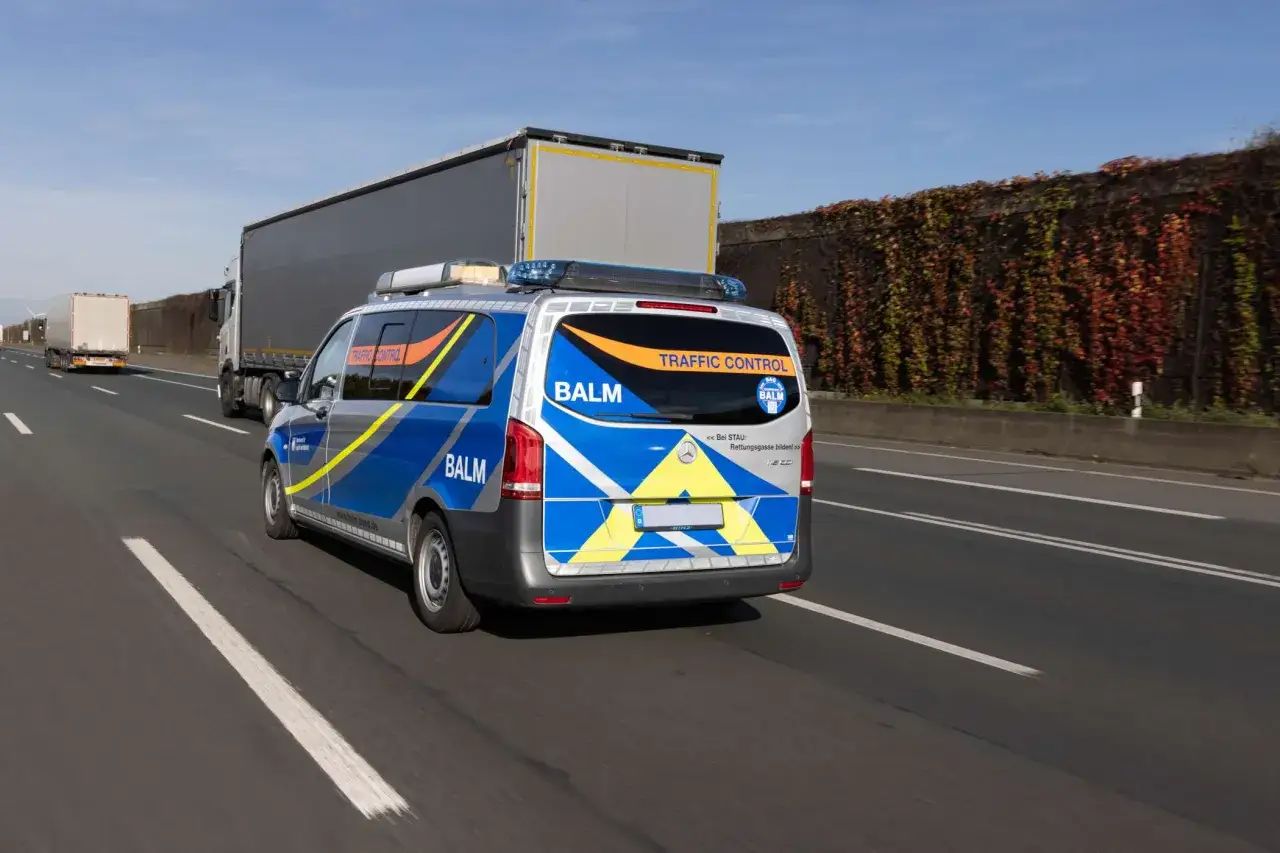 BALM-Fahrzeug auf Autobahn, &uuml;berwacht den Werkverkehr. LKW fahren vorbei.