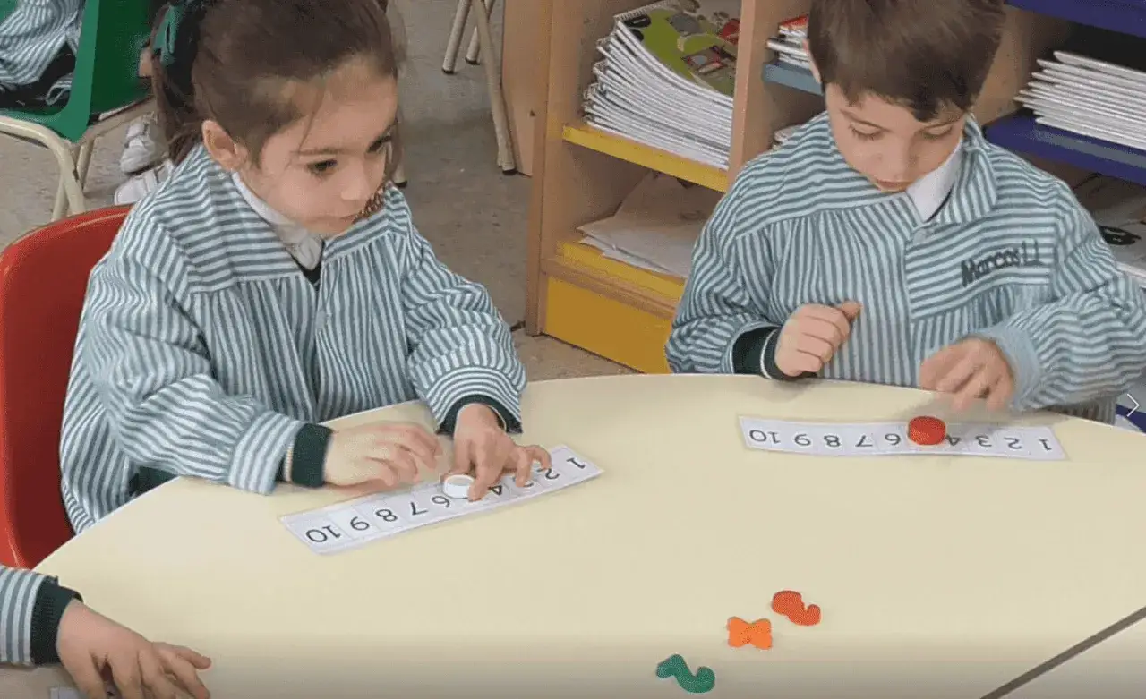 Ni&ntilde;os aprendiendo con el m&eacute;todo ABN infantil, colocando fichas en tiras num&eacute;ricas.