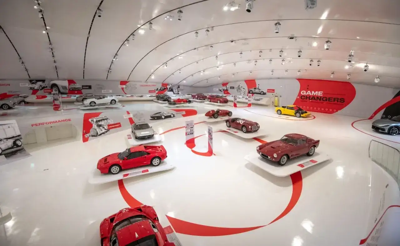 W muzeum Ferrari prezentowane są ikoniczne modele samochodów, od klasycznych po nowoczesne, w tym czerwone Ferrari F40 i żółte Ferrari.