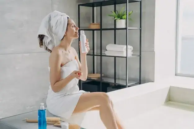 kobieta nakładająca balsam na skórę przed perfumami
