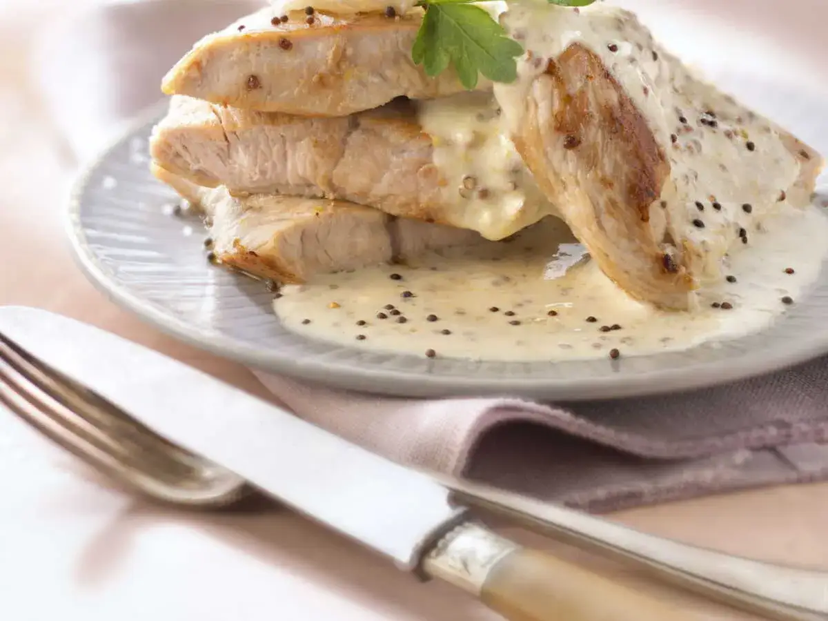 D&eacute;licieuse escalope de dinde napp&eacute;e d'une sauce cr&eacute;meuse &agrave; la moutarde, garnie de persil frais. Un plat savoureux pr&ecirc;t &agrave; &ecirc;tre d&eacute;gust&eacute;.