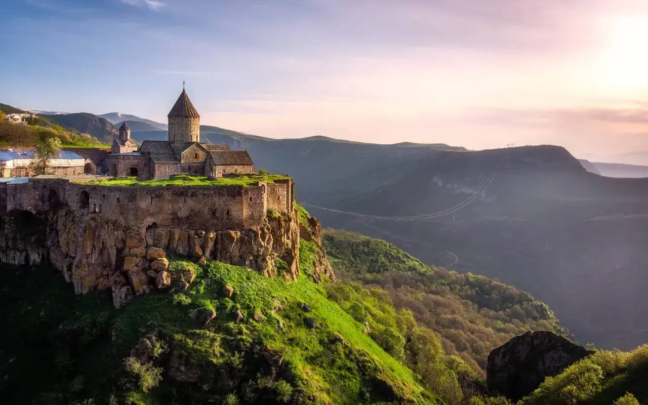 Klasztor Tatew na skale, wspaniały widok na **Armenię co zobaczyć**. Zielone wzgórza i góry w tle.
