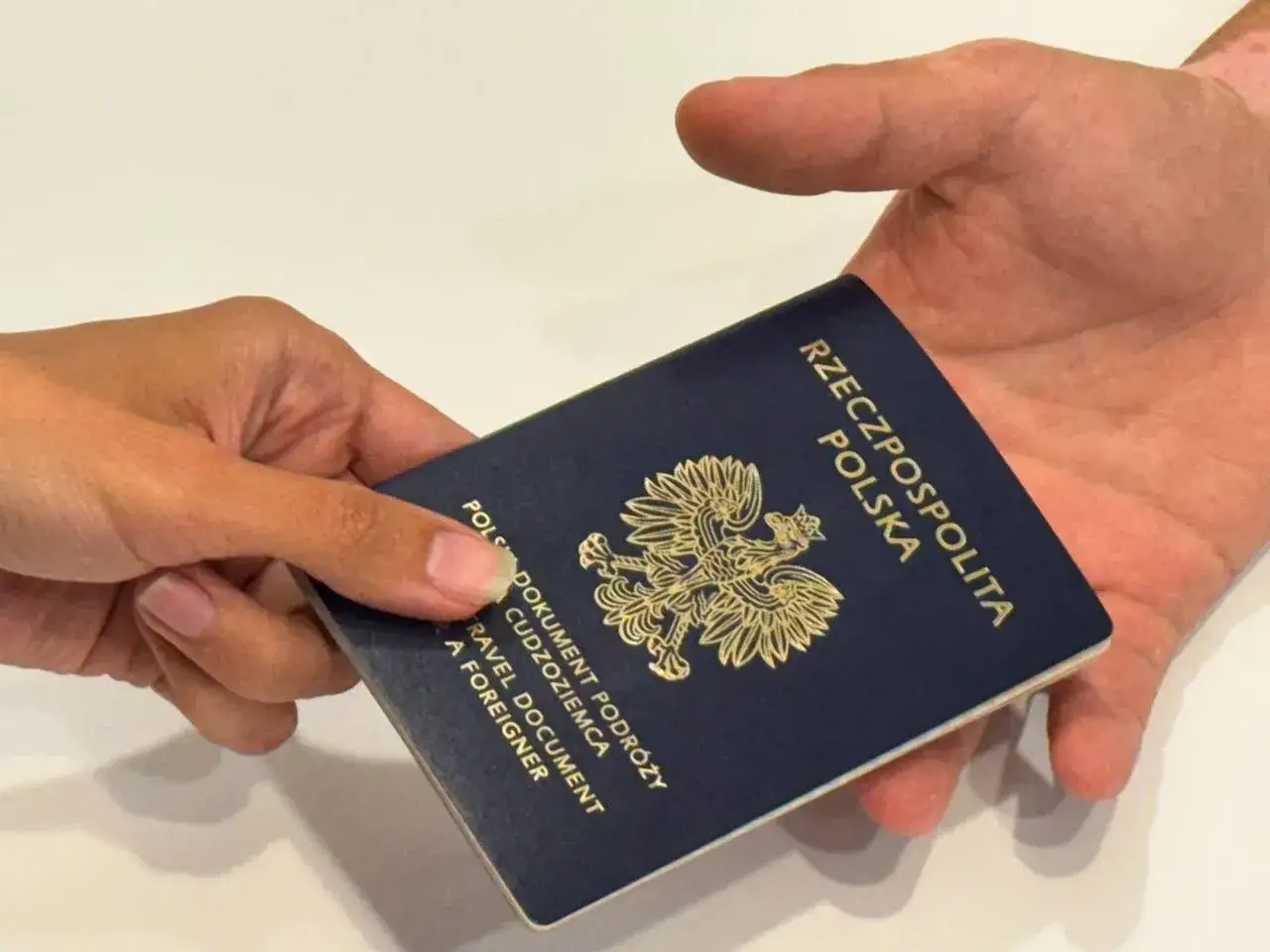 Dłoń podaje paszport. Czy do Słowenii potrzebny jest paszport? Tak, to polski dokument podróży.