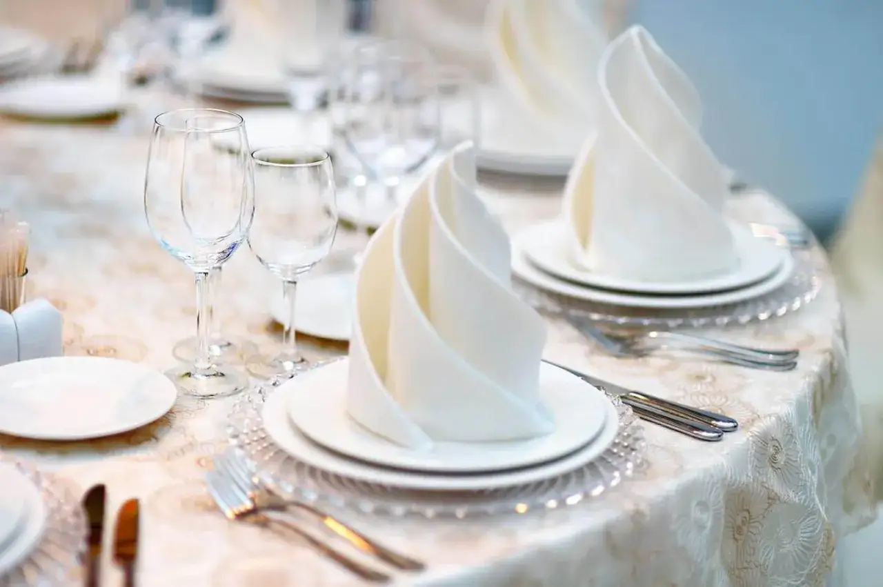 Elegante Tischdeko mit kunstvoll gefalteten Servietten, Gl&auml;sern und Besteck. Perfekt f&uuml;r ein festliches Essen.
