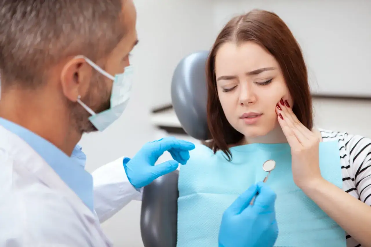 Pacjentka z bólem zęba, prawdopodobnie zapalenie miazgi, podczas wizyty u dentysty.