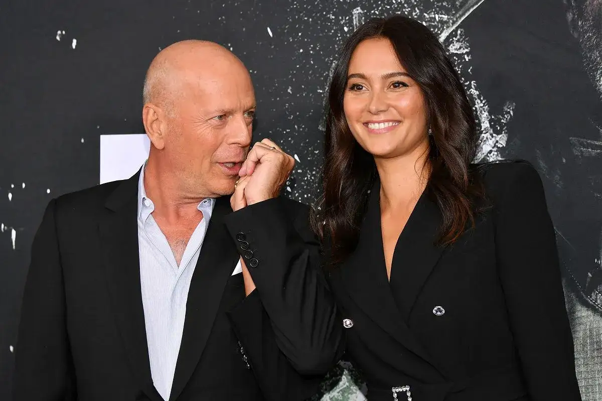 Bruce Willis i jego żona Emma Heming-Willis, uśmiechnięci i blisko siebie, pozują do zdjęcia.