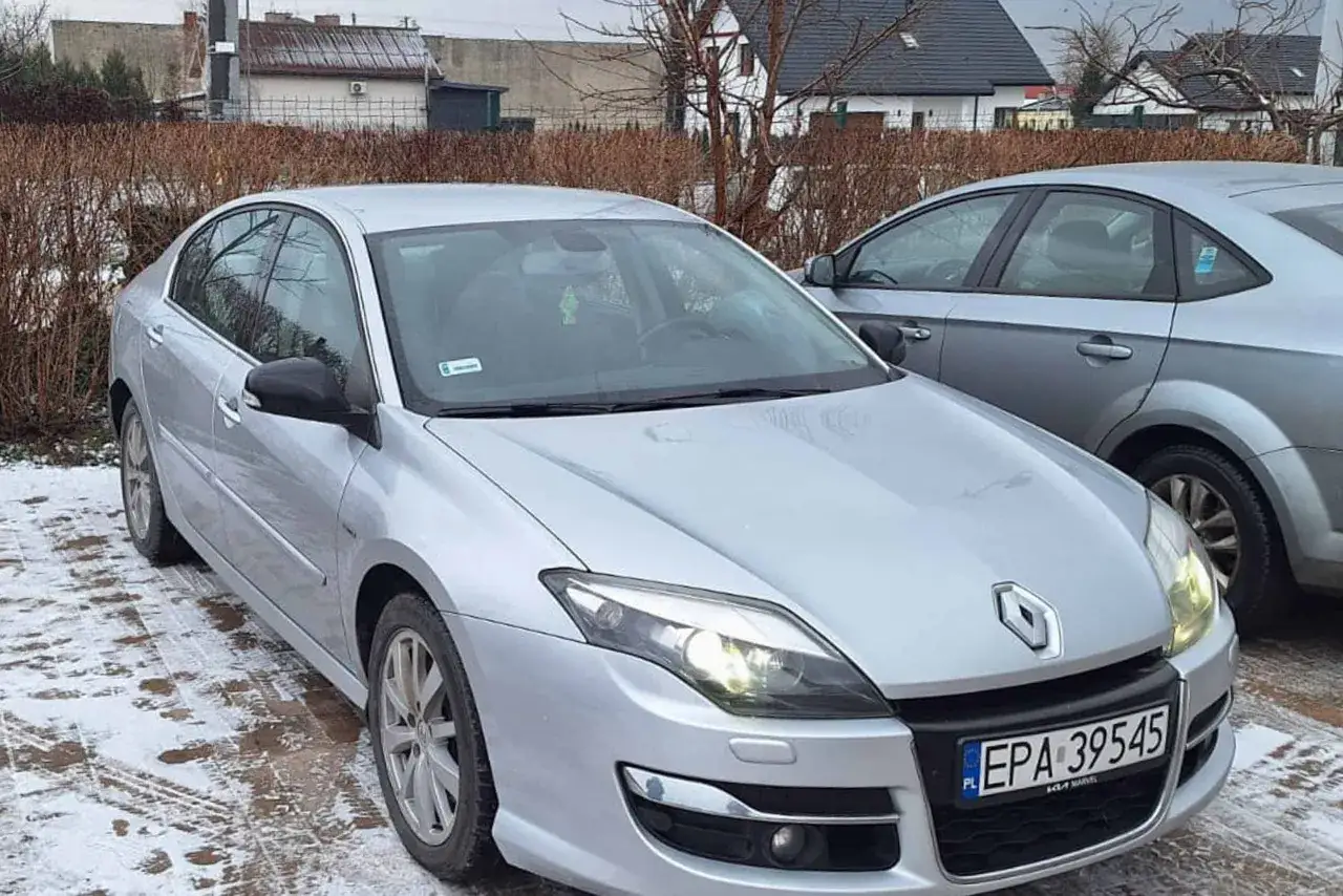 Srebrna Laguna 3 2.0 dCi z tablicą EPA 39545 zaparkowana na zaśnieżonym podjeździe.