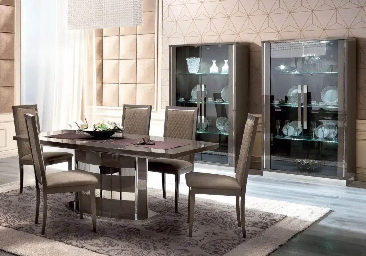 Table et chaises modernes pour aménager salle à manger. Vitrines élégantes avec vaisselle et décorations.