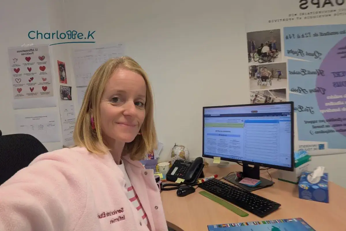 Charlotte, une master infirmier &agrave; distance, travaille &agrave; son bureau. Elle porte une veste rose et des boucles d'oreilles roses.