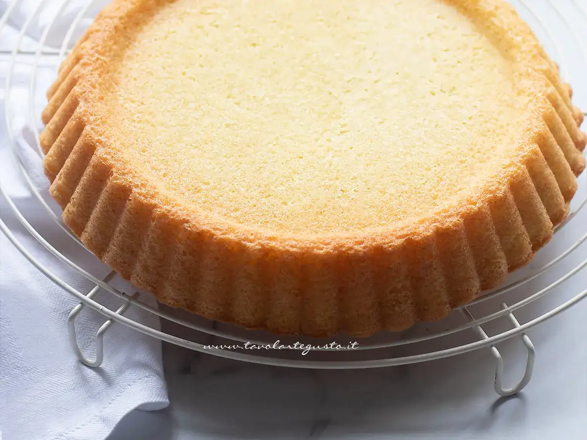 Una torta furba dorata e soffice, appena sfornata, riposa su una gratella. Perfetta per ogni occasione.