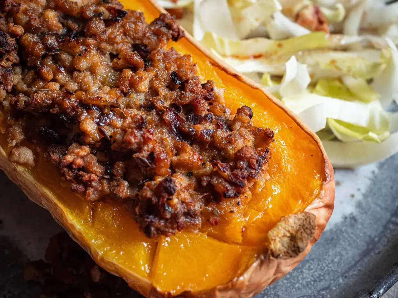 Courge de butternut r&ocirc;tie, garnie d'une farce savoureuse, accompagn&eacute;e d'une salade croquante. Un plat r&eacute;confortant et color&eacute;.