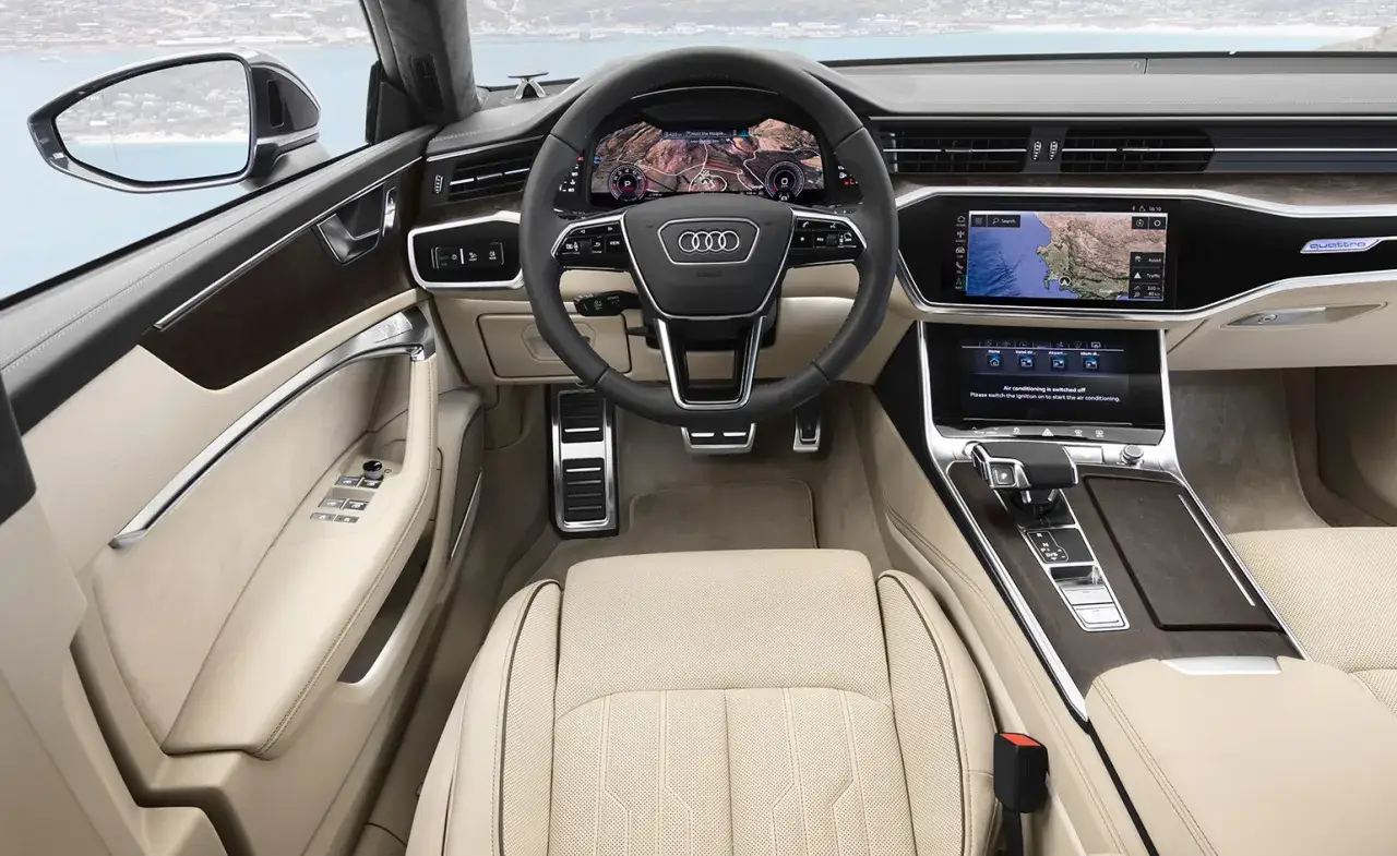 Wnętrze Audi A7 z jasną tapicerką i nowoczesnymi ekranami. Sprawdź audi a7 cena i poczuj luksus.