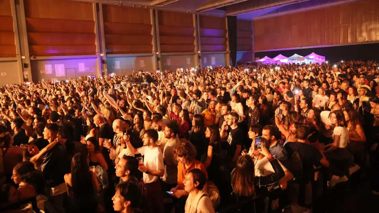 Multitud disfrutando un concierto, con luces y celulares en alto. Los **fiz horarios** de este evento son un éxito.