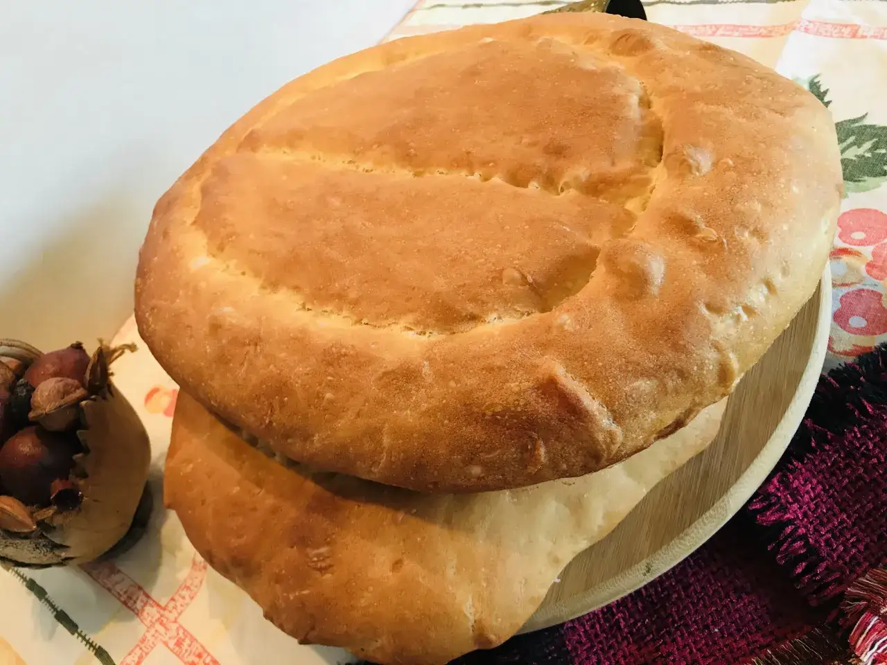 Dwa okrągłe, złociste bochenki chleba, jeden na drugim. To właśnie lawasz, co to za pyszny wypiek!