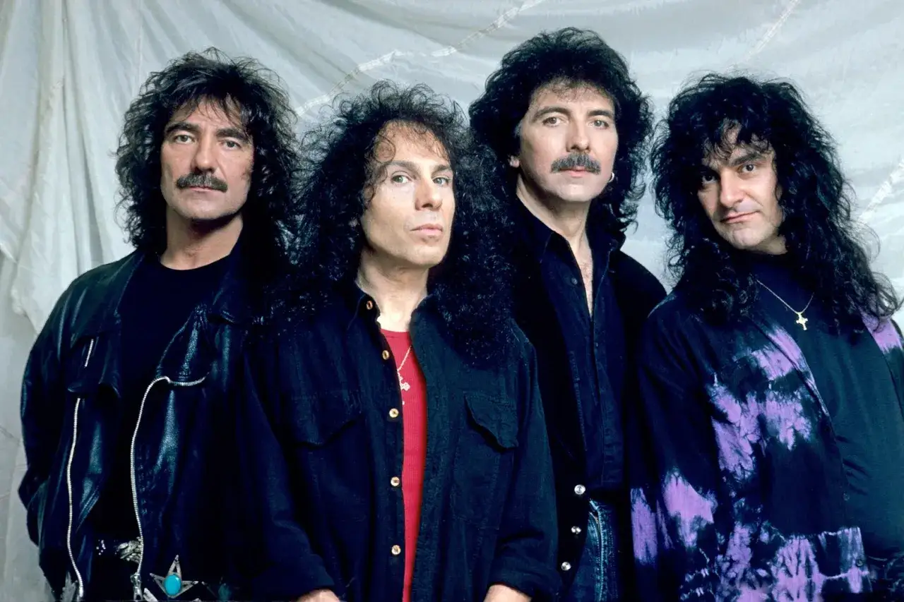 Czterech muzyków, w tym wokalista Black Sabbath Ronnie James Dio, pozuje do zdjęcia.