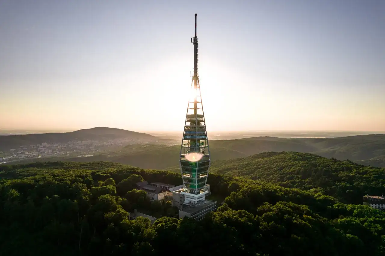 Sonnenaufgang &uuml;ber Bratislava: Der Fernsehturm Kamz&iacute;k ragt &uuml;ber bewaldete H&uuml;gel. Ein toller Ort f&uuml;r Bratislava Geheimtipps!
