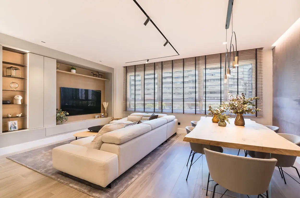 Salón moderno con sofá modular, mesa de comedor de madera y decoración que evoca el feng shui, creando un ambiente sereno y equilibrado.