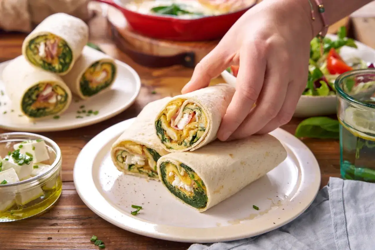 Pyszna tortilla ze szpinakiem, jajecznicą i fetą, gotowa do zjedzenia.