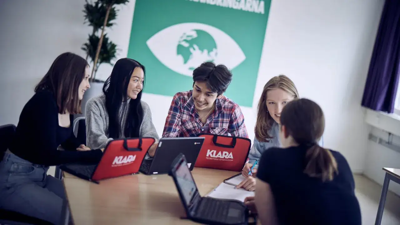 Elever p&aring; Klara Norra gymnasium samarbetar kring laptops.