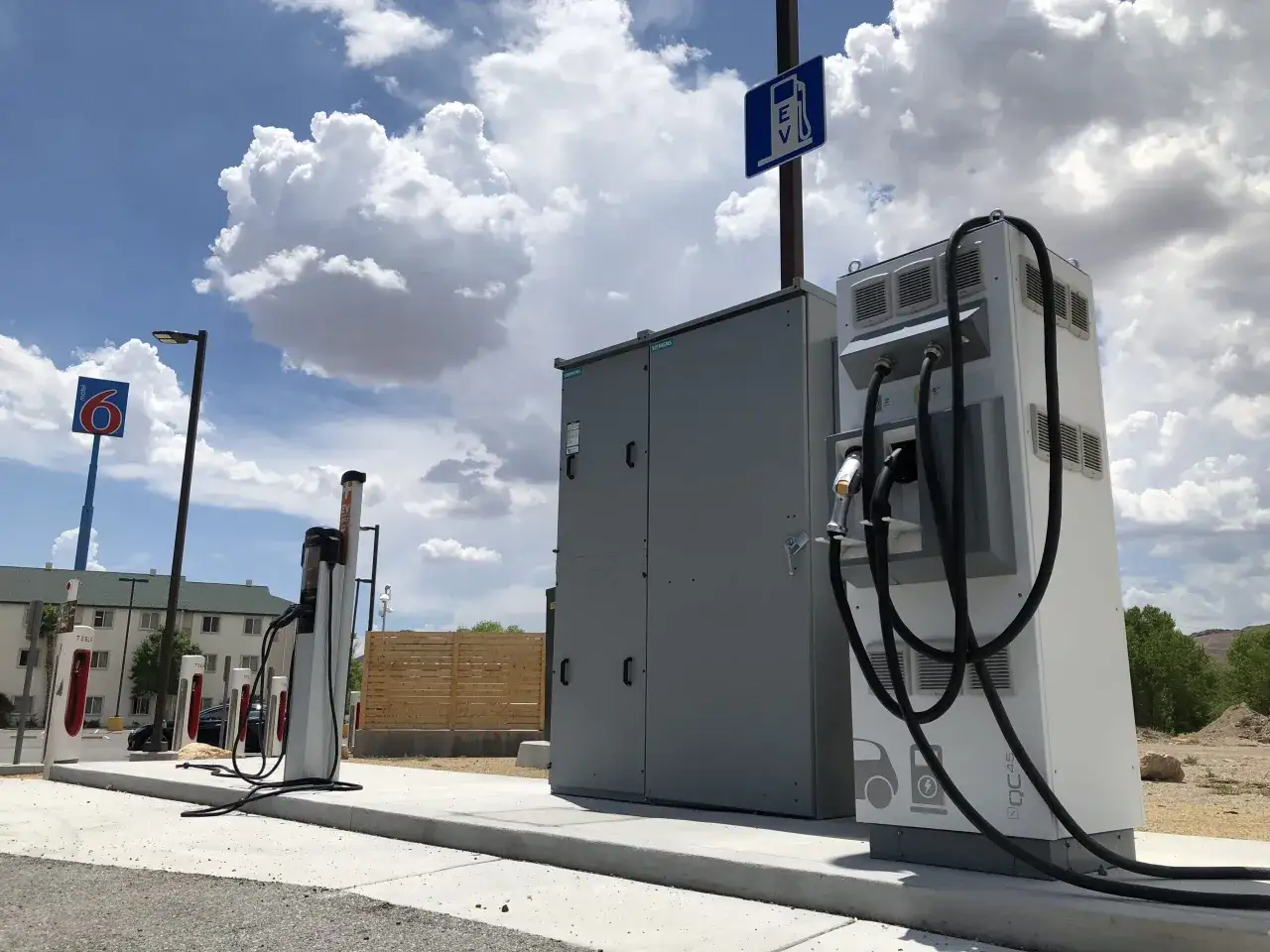Stazione di ricarica per auto elettriche, con colonnine Tesla e Siemens. Un confronto sul costo km auto elettrica vs diesel è sempre più attuale.