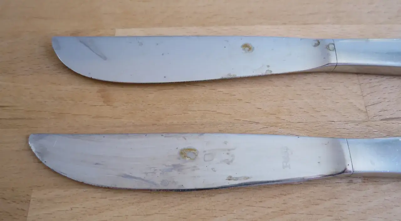 Zwei Messer mit deutlichen Rostflecken auf dem Metall. Das Besteck scheint alt zu sein und ben&ouml;tigt eine Reinigung.