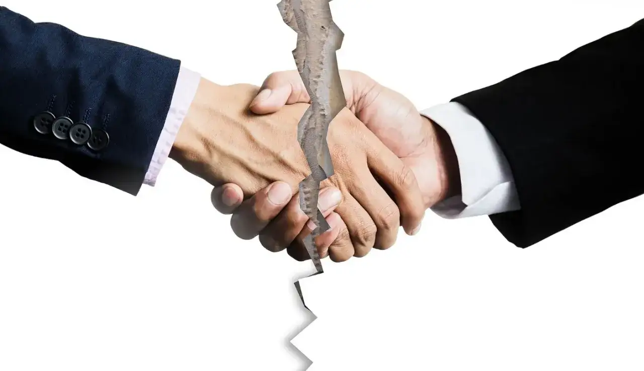 Rozłamane dłonie w geście uścisku symbolizują przegraną sprawę o zasiedzenie. Co dalej?