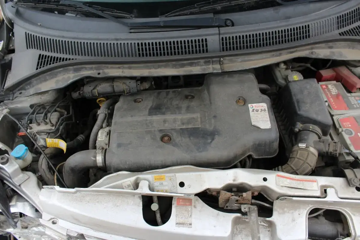 Silnik Suzuki Swift 2007, zakurzony, z widocznym filtrem powietrza i akumulatorem.