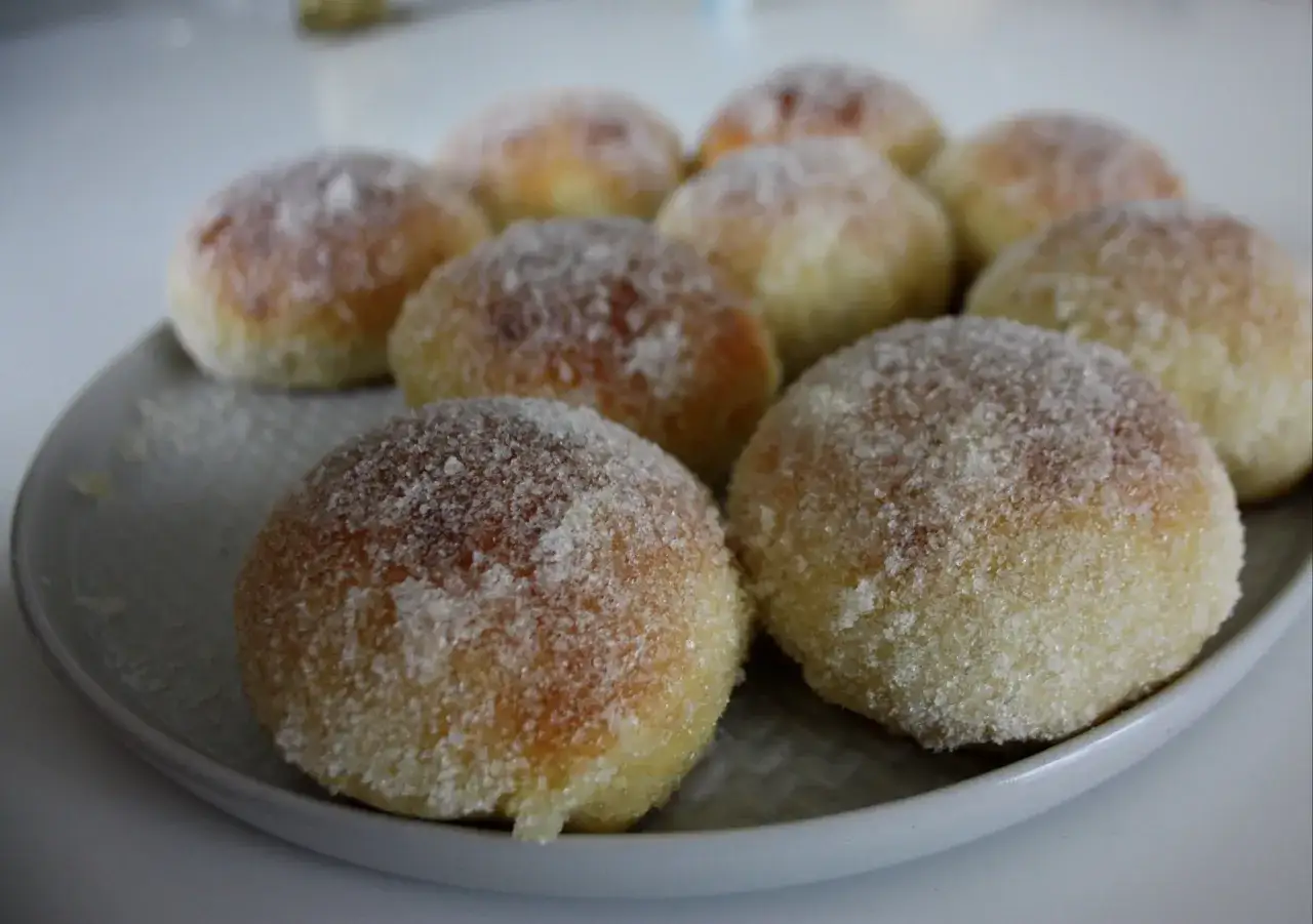 En tallrik med nybakade bullar, gener&ouml;st t&auml;ckta med str&ouml;socker p&aring; bullar. Perfekt f&ouml;r fikat!