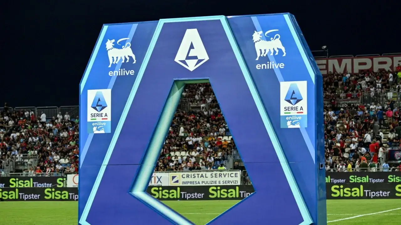 Brama wejściowa na stadion z logo Serie A i symbolem EniLive. Tłum kibiców na trybunach, gotowy do emocjonujących rozgrywek Serie A.