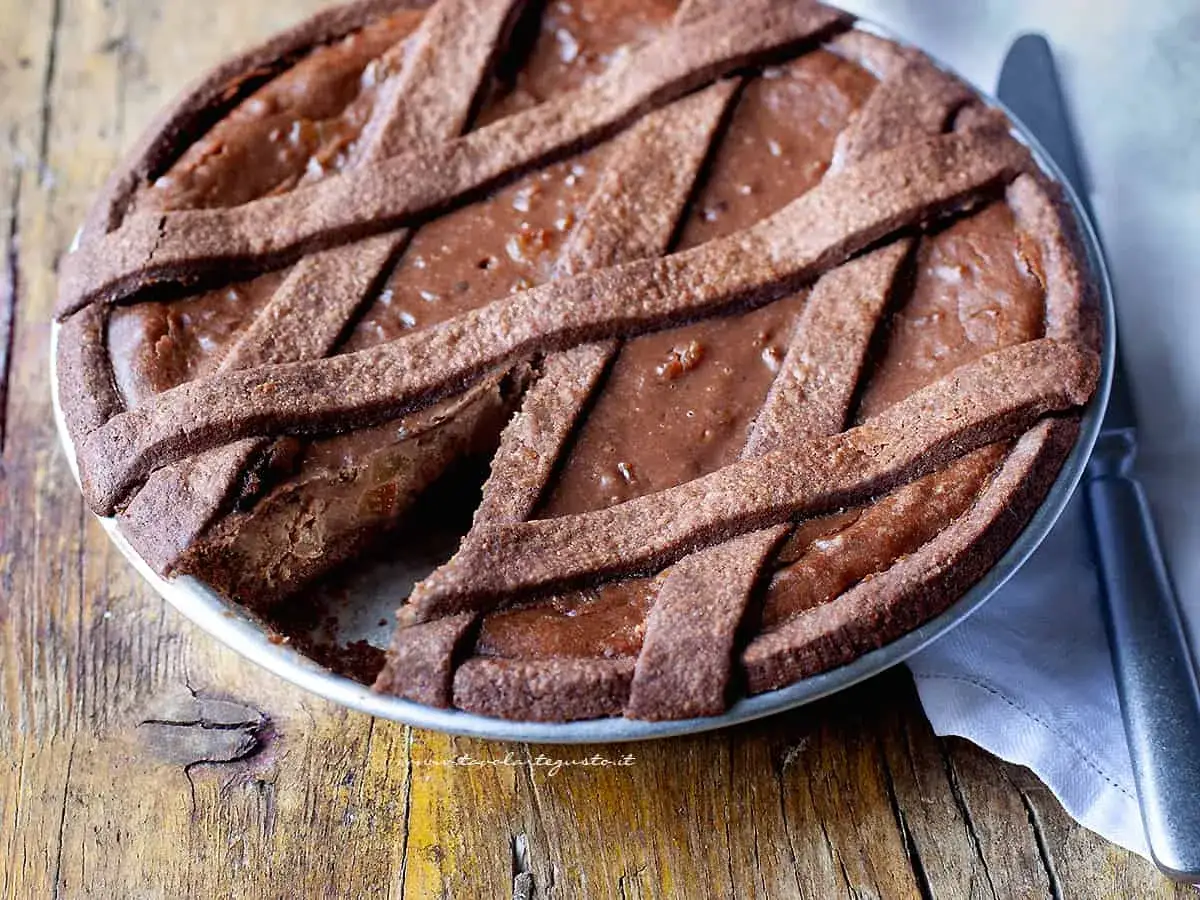 Una deliziosa pastiera al cioccolato con una crostata intrecciata, pronta per essere gustata.