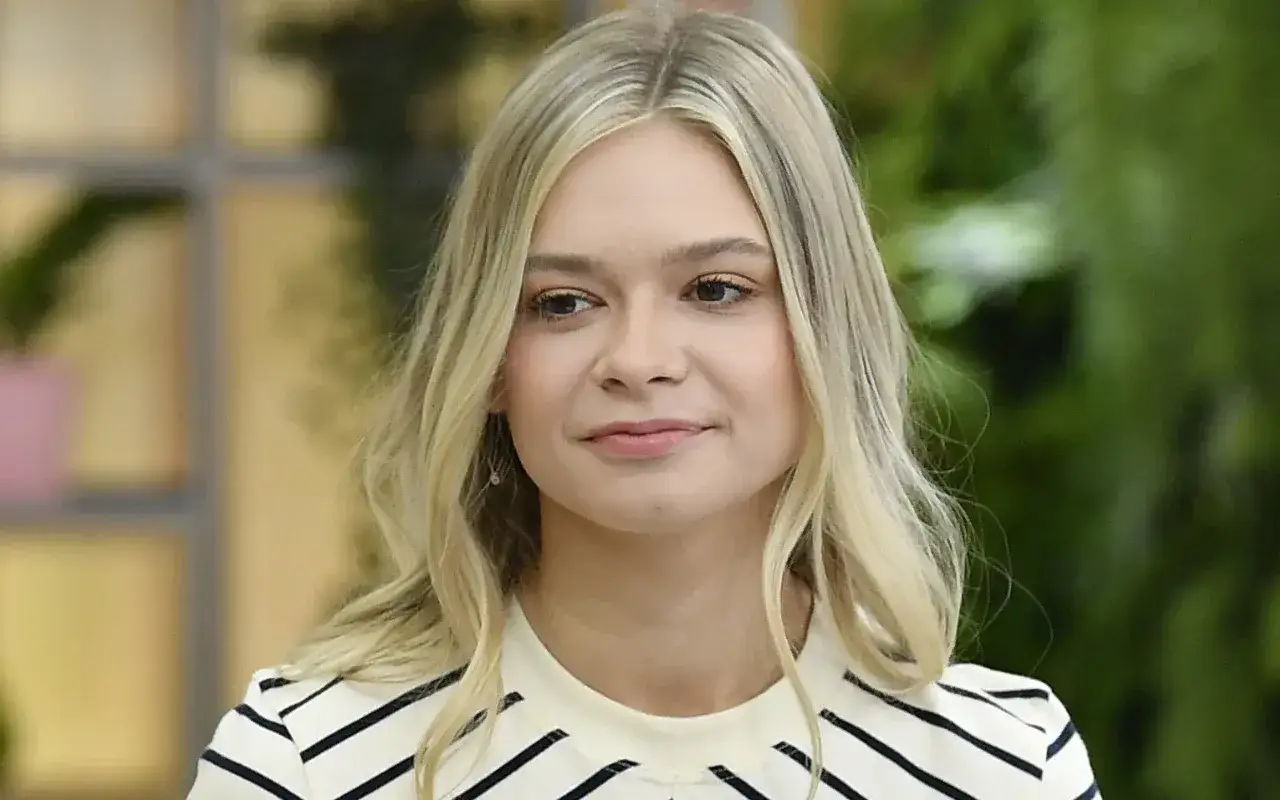 Julia Wróblewska, znana z wielu ról filmowych, uśmiecha się lekko.