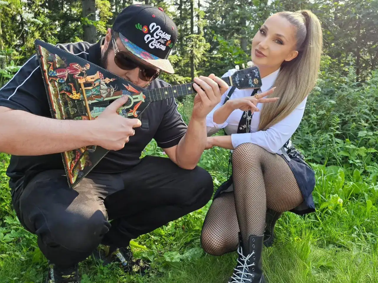 Cleo, która ma 39 lat, pozuje z mężczyzną grającym na ozdobnej gitarze w lesie.