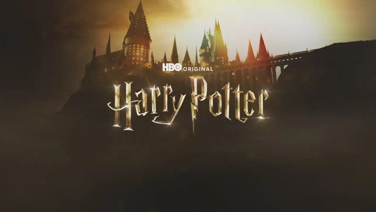 Hogwart w blasku zachodzącego słońca, złote logo 