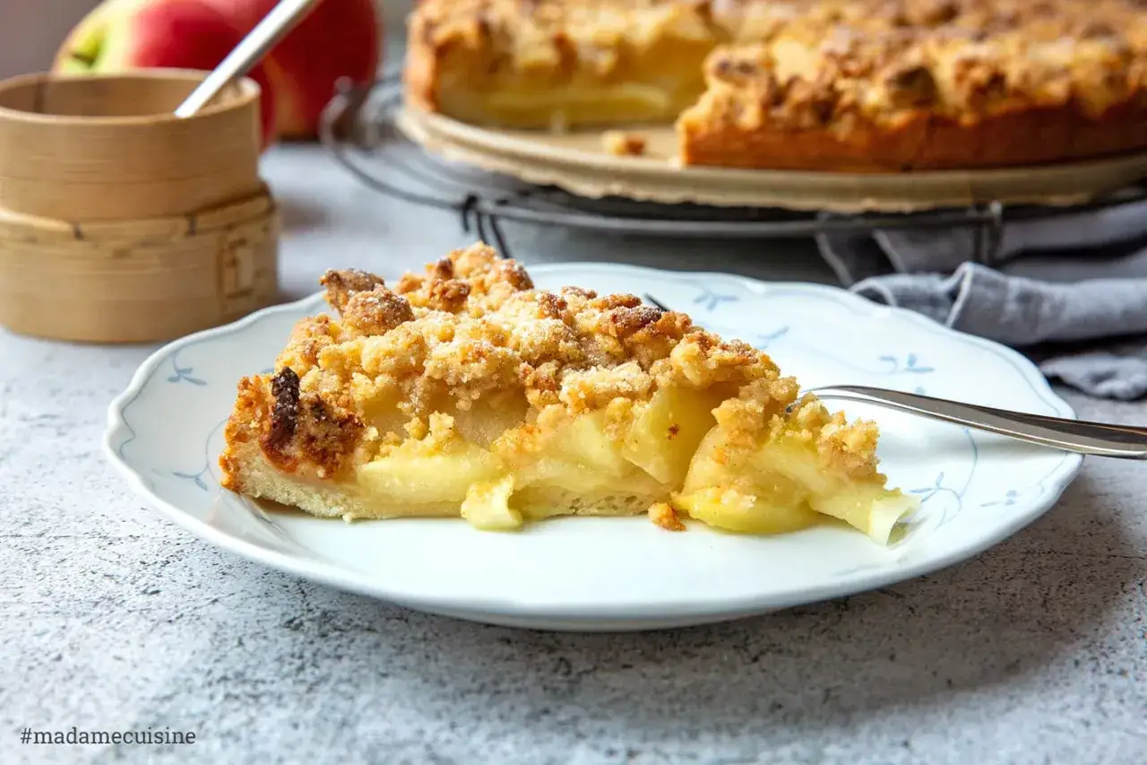 Ein Stück saftiger Apfelkuchen mit Streuseln, wie von den Landfrauen gebacken. Perfekt für gemütliche Nachmittage, inspiriert von traditionellen Landfrauen Kuchen Rezepten.