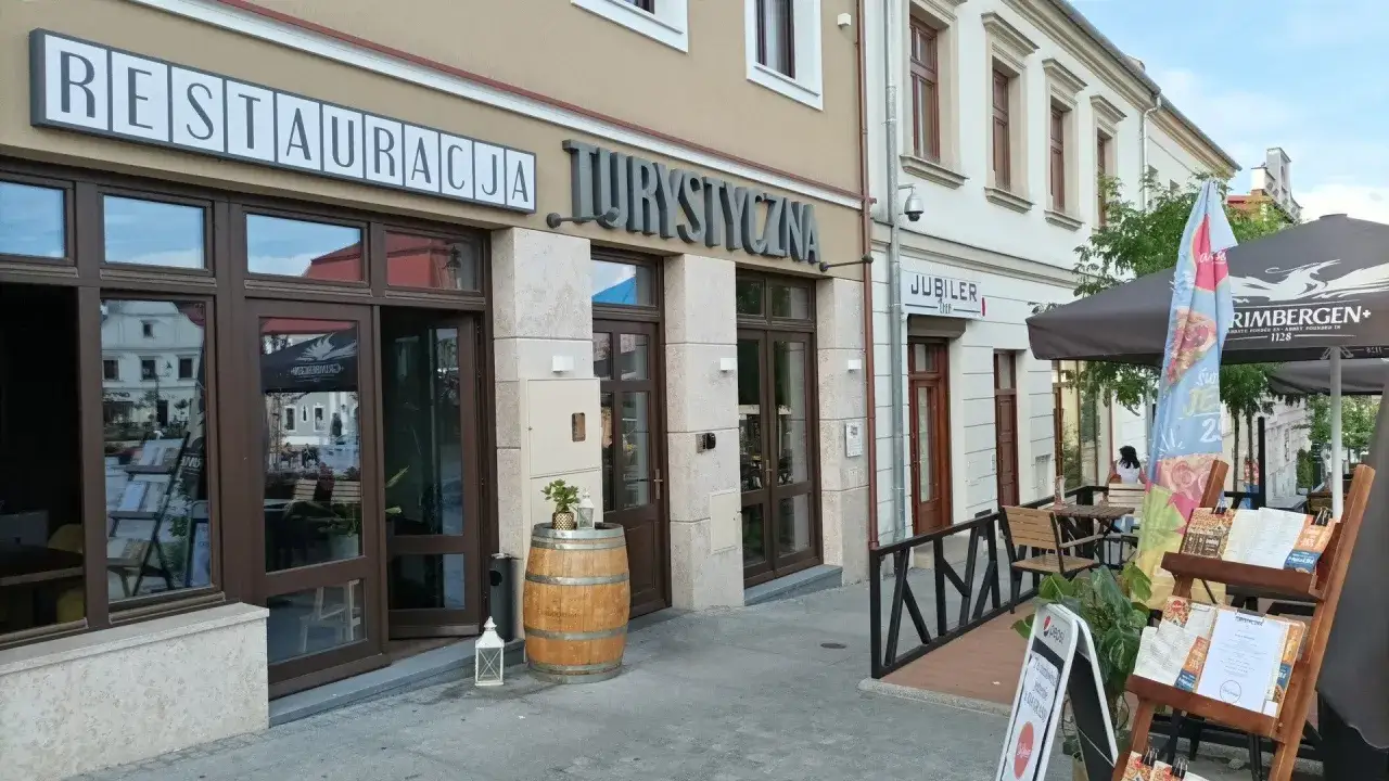 Restauracja Turystyczna w Bochni zaprasza na posiłek. Zobacz, gdzie zjeść w Bochni, siedząc przy stoliku pod parasolem.