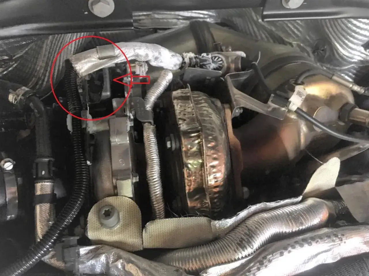 Zone rouge sur un moteur, indiquant une possible fuite injecteur AdBlue. Composants du turbo et tuyaux isol&eacute;s visibles.