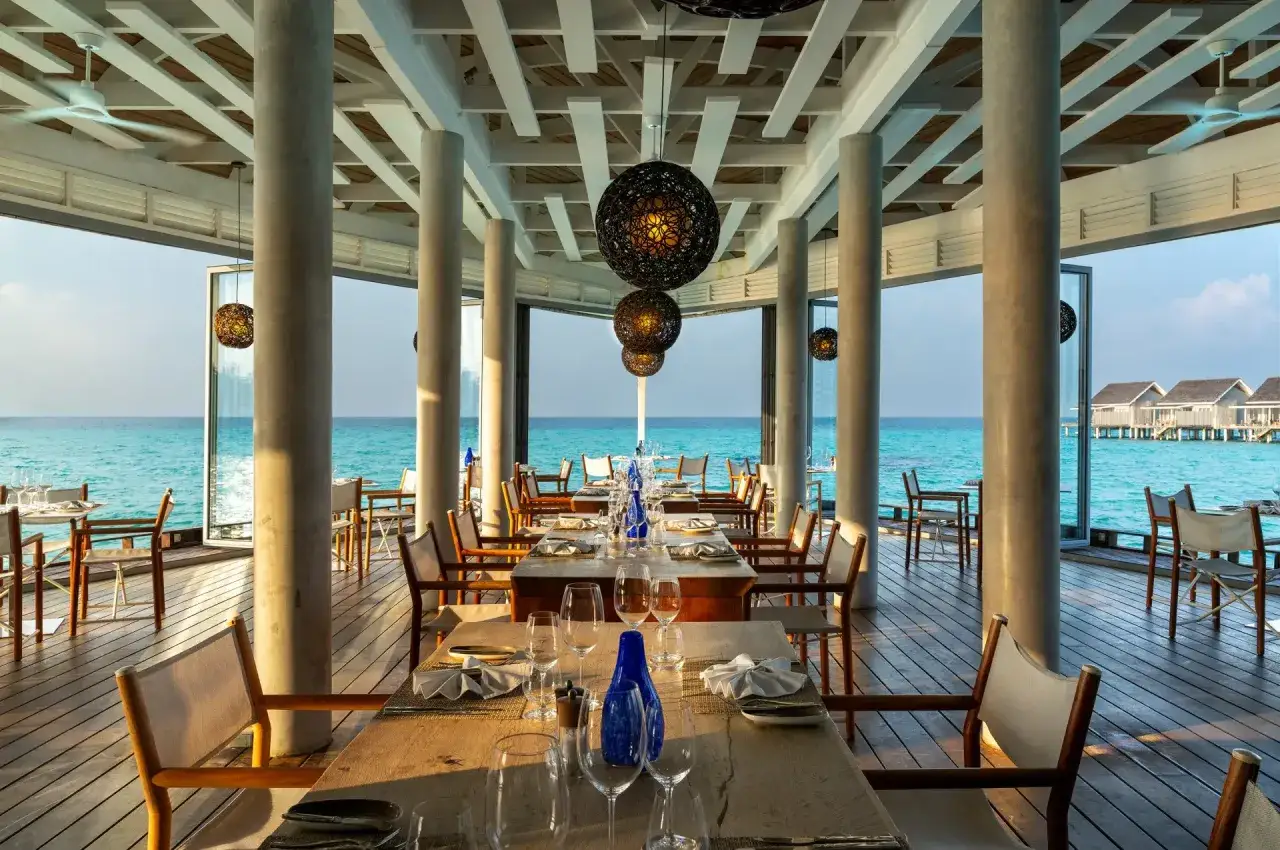 Elegant restaurang med dukade bord och havsutsikt p&aring; Maldiverna. Ving Maldiverna erbjuder en of&ouml;rgl&ouml;mlig matupplevelse.
