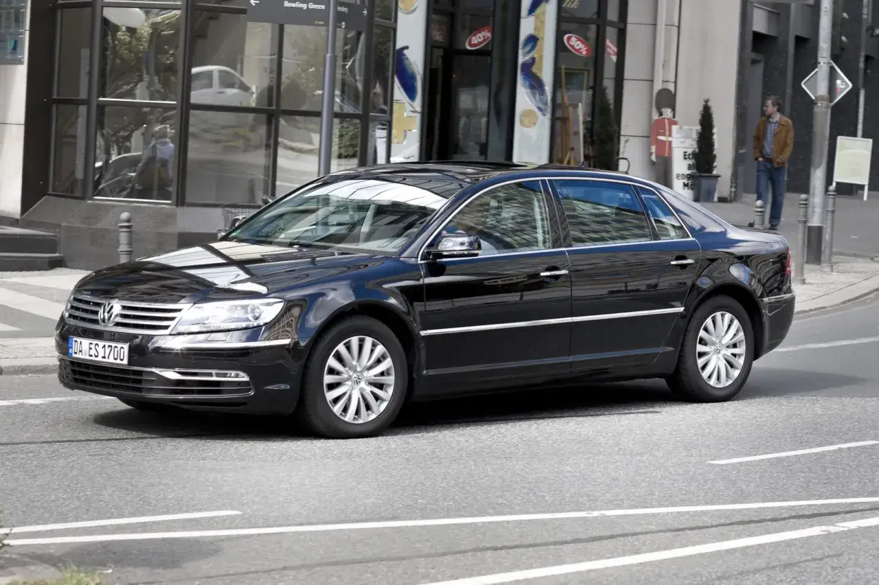 Czarny Volkswagen Phaeton, idealne auto do 20 tys. zł, sunie ulicą. Elegancki, przestronny, z pewnością sprawdzi się w każdej sytuacji.