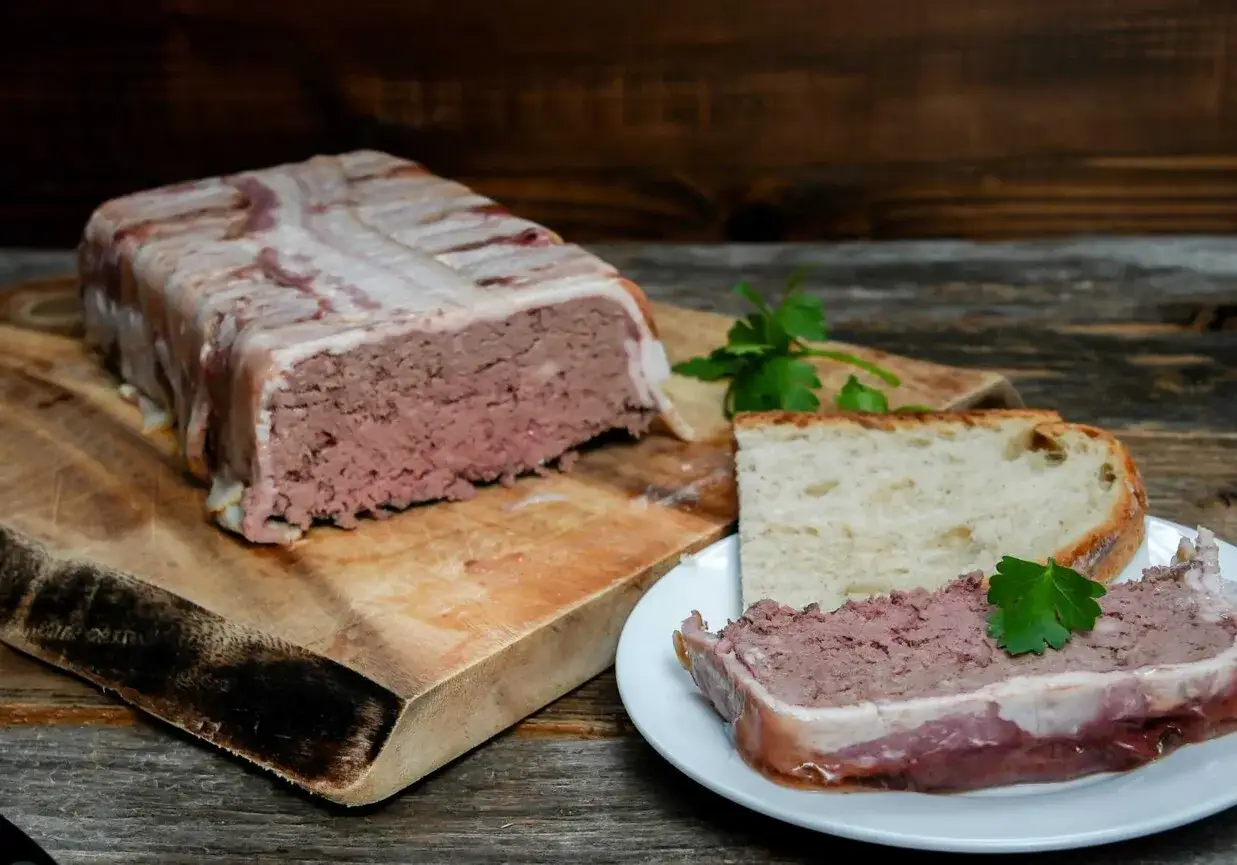 Pate zawinięte w boczek, pokrojone na talerzyku z chlebem. Pyszne pate, idealne na przekąskę.