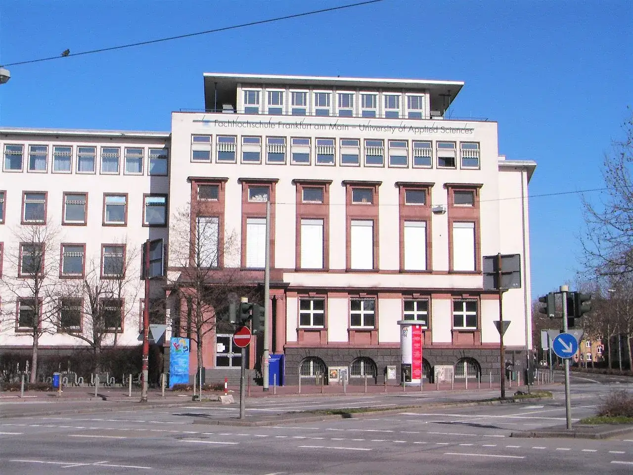 Die Fachhochschule Frankfurt am Main – University of Applied Sciences, kurz ESM Frankfurt am Main, zeigt ihre moderne Fassade unter blauem Himmel.