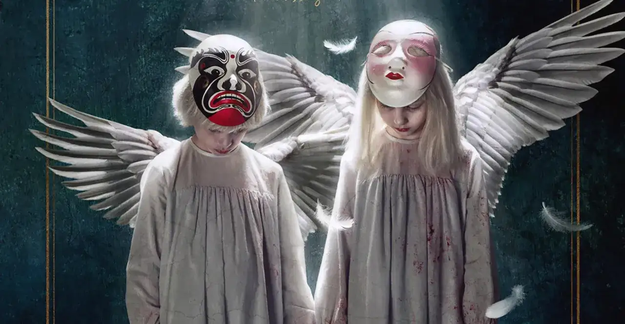 Zwei Kinder, Tin und Tina, mit Engelsflügeln und Masken, blicken nach unten. Federn schweben um sie herum.