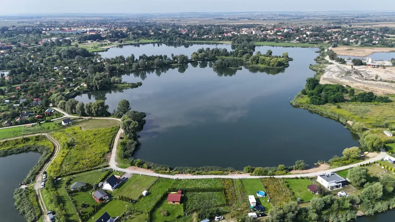 Malownicze łowisko Radymno z licznymi domkami i zielenią.
