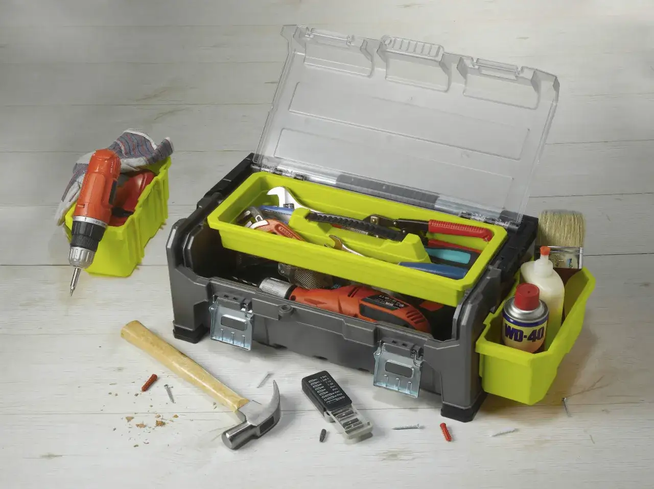 Boîte à outils ouverte avec divers nom d'outils de bricolage : perceuse, marteau, clés, pince, tournevis, pinceau, colle et WD-40.