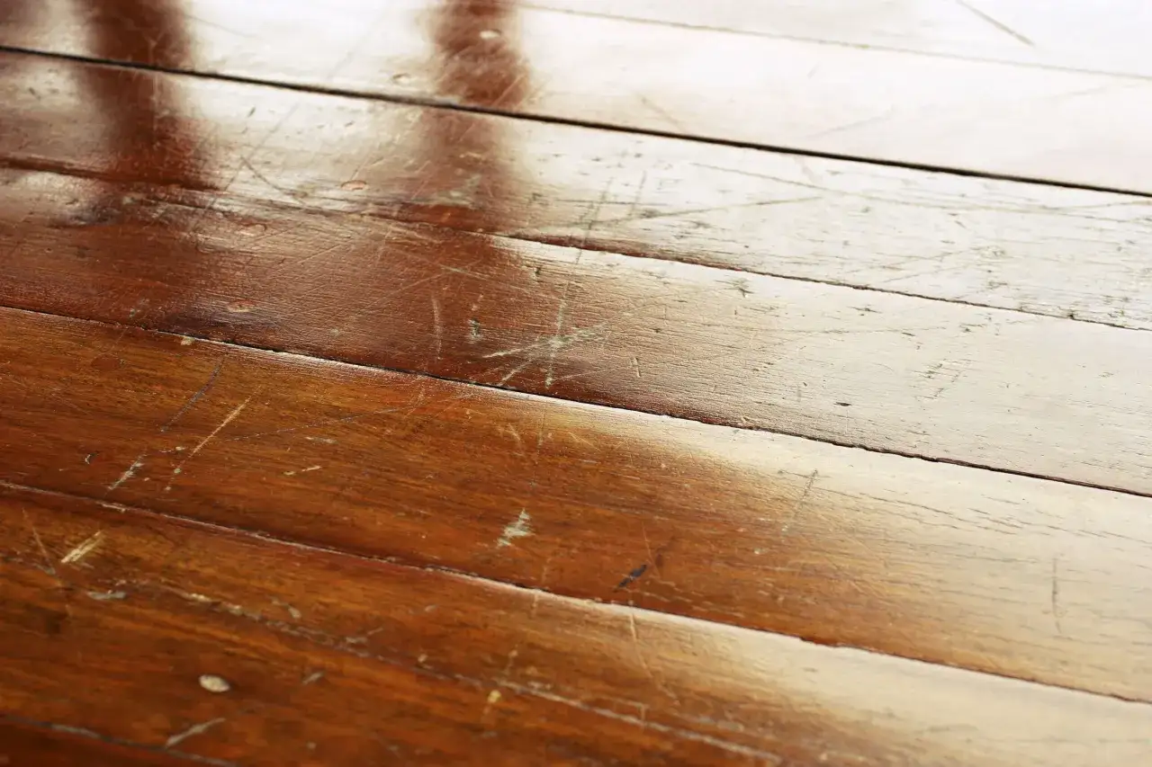 Parquet de madera con arañazos y marcas. Busca remedios caseros para reparar parquet y devolverle su brillo.