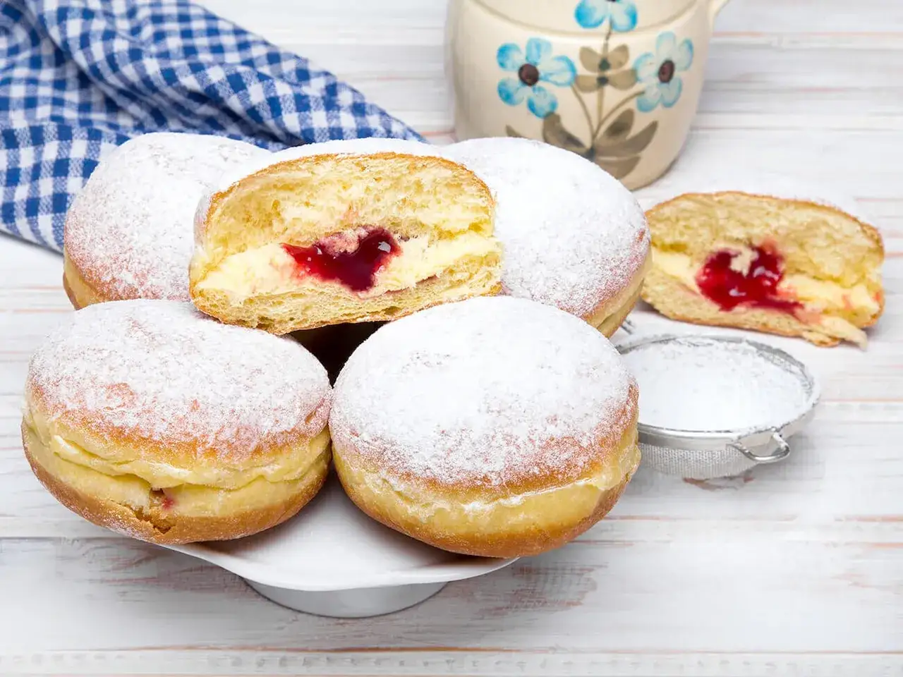 Szybkie pączki z piekarnika, puszyste i obficie posypane cukrem pudrem, z pysznym, czerwonym nadzieniem.